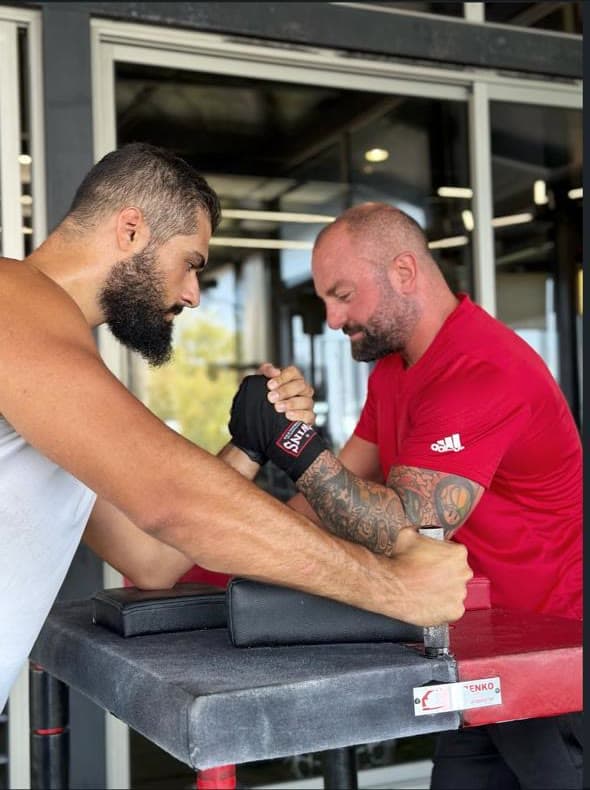 Two members arm wrestling on the terrace table